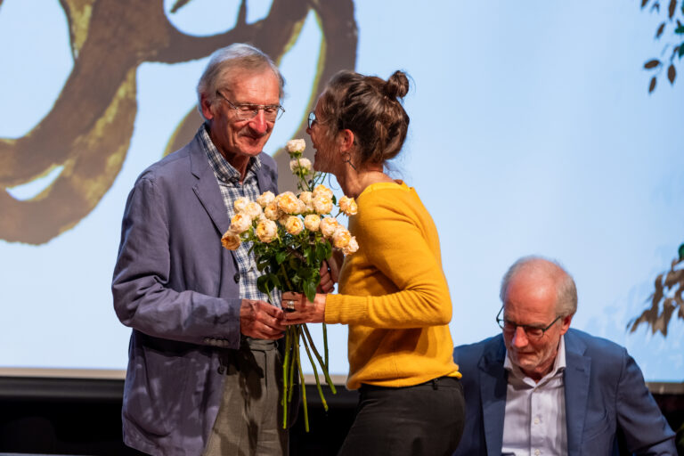 Paul Claes krijgt bloemen in de Bib Leuven. Foto: Bart Wierinckx